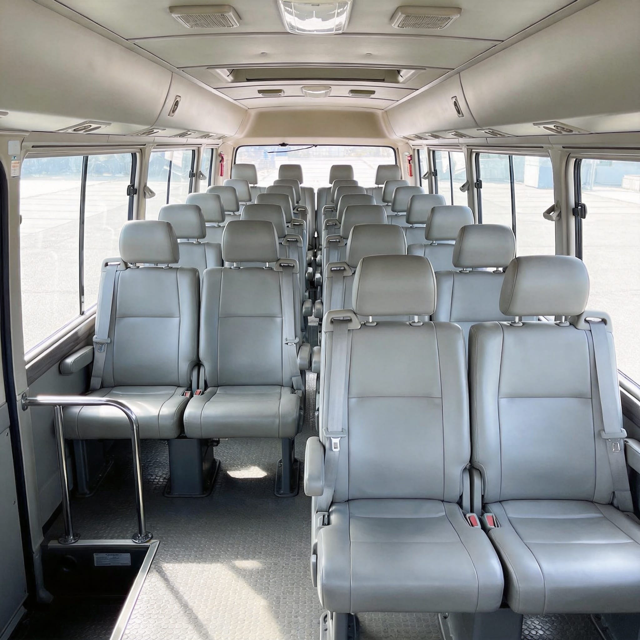 Toyota Coaster 23 con configuración de asientos y amplio espacio entre asientos.